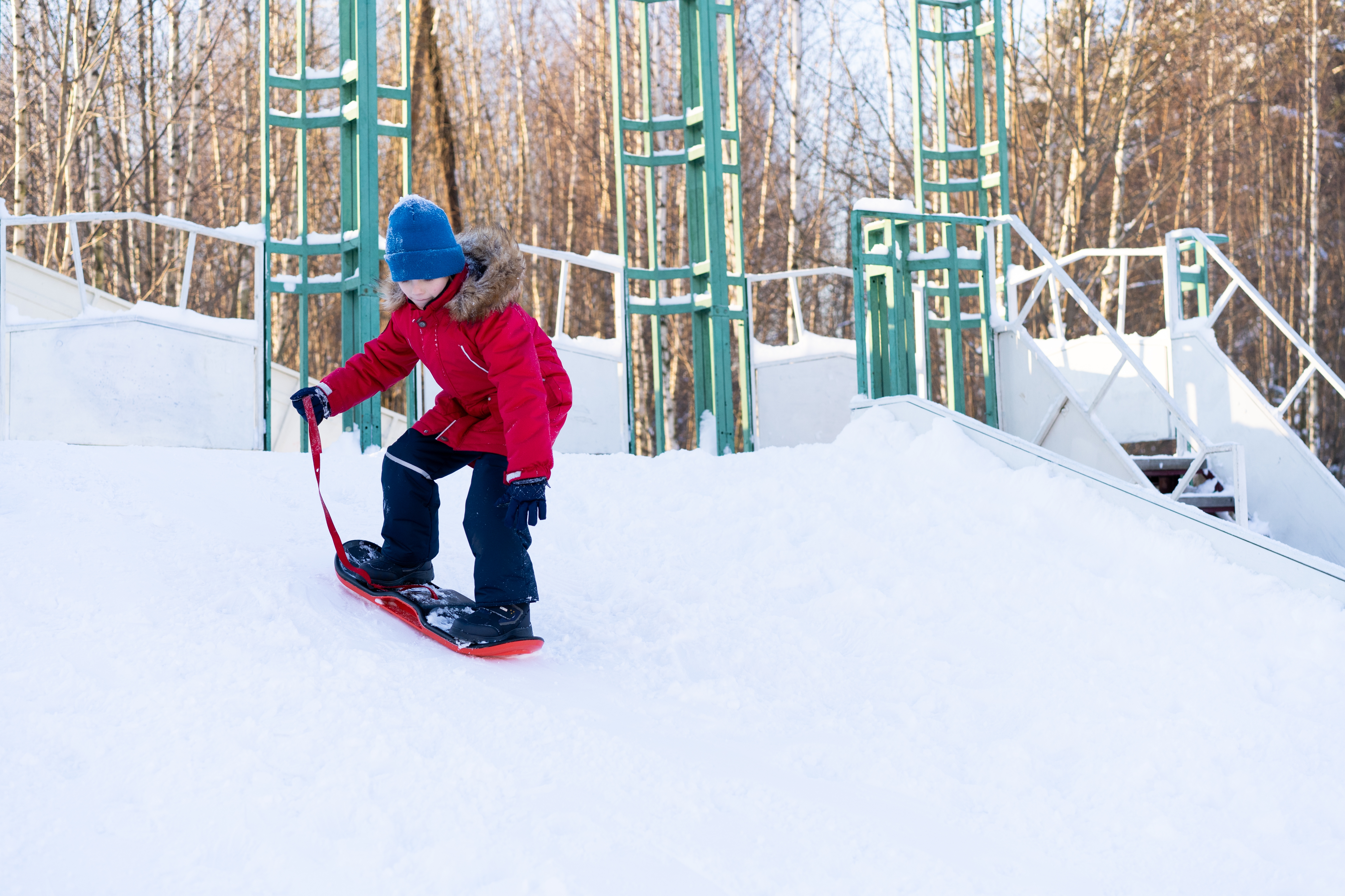 The boy learns to ride children's snowboarding, winter sports